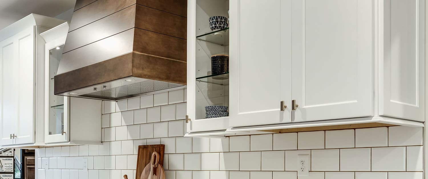 Built-in range hood liner concealed inside custom wood hood.